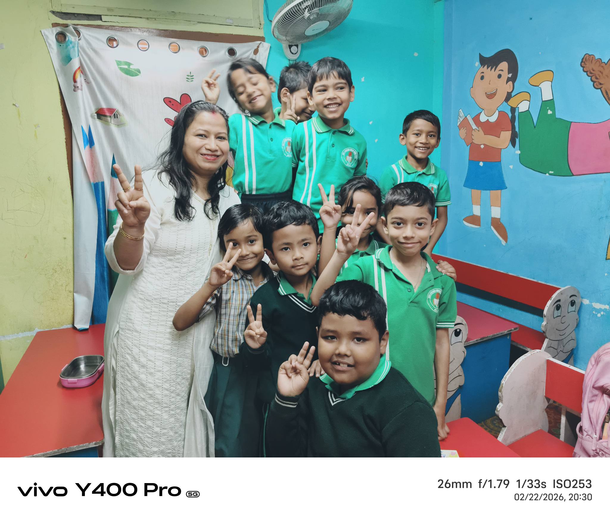 Caring teacher with young students in a classroom
